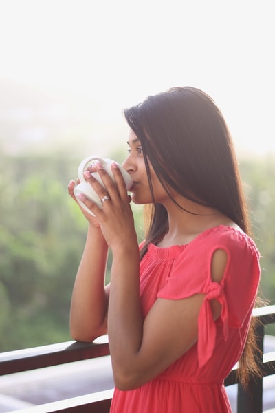 女人喝白色的陶瓷杯
